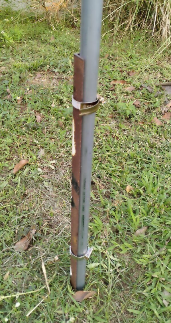 Mast attached to a steel angle stake with two hose clamps